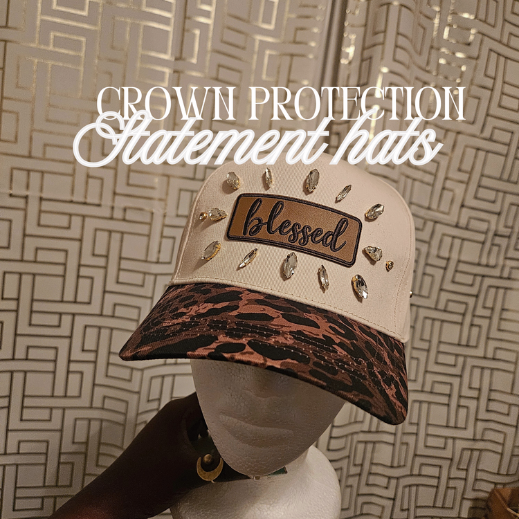 A display of the custom-embellished Crown Protection Statement Hats by Jazzy Cherrie, featuring a luxury rhinestone-studded beanie with a massive crystal bow and a graphic structured cap with gold sequin vines.
